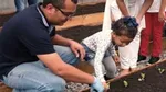 Man and young girl planting lettuce plants in our onsite garden at Pouso Alegre, Brazil.