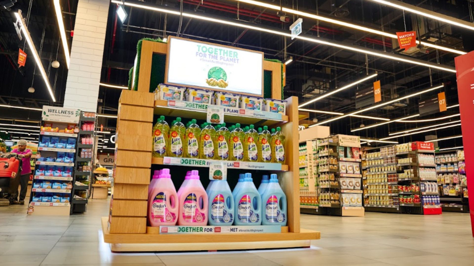 Supermarket display of cleaning products under a “Together for the Planet” sign.