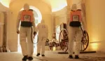 Three cleaners wearing protective clothing and carrying Lysoform spray backpacks in one of Italy’s main museums.