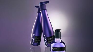 Three bottles of Nexxus Keraphix products. Lilac bottles of shampoo and conditioner, and a smaller metallic bottle with black pump.