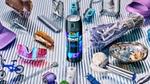 A flatlay photo with a can of Axe Blue Lavender fine fragrance deodorant spray in the centre. Also pictured are sunglasses, a Nintendo controller, a razor and a spray of lavender.