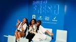Three women smile for a photo at Unilever's House of Fresh. Dove, Dove Men+Care and Rexona logos are on the wall behind them.